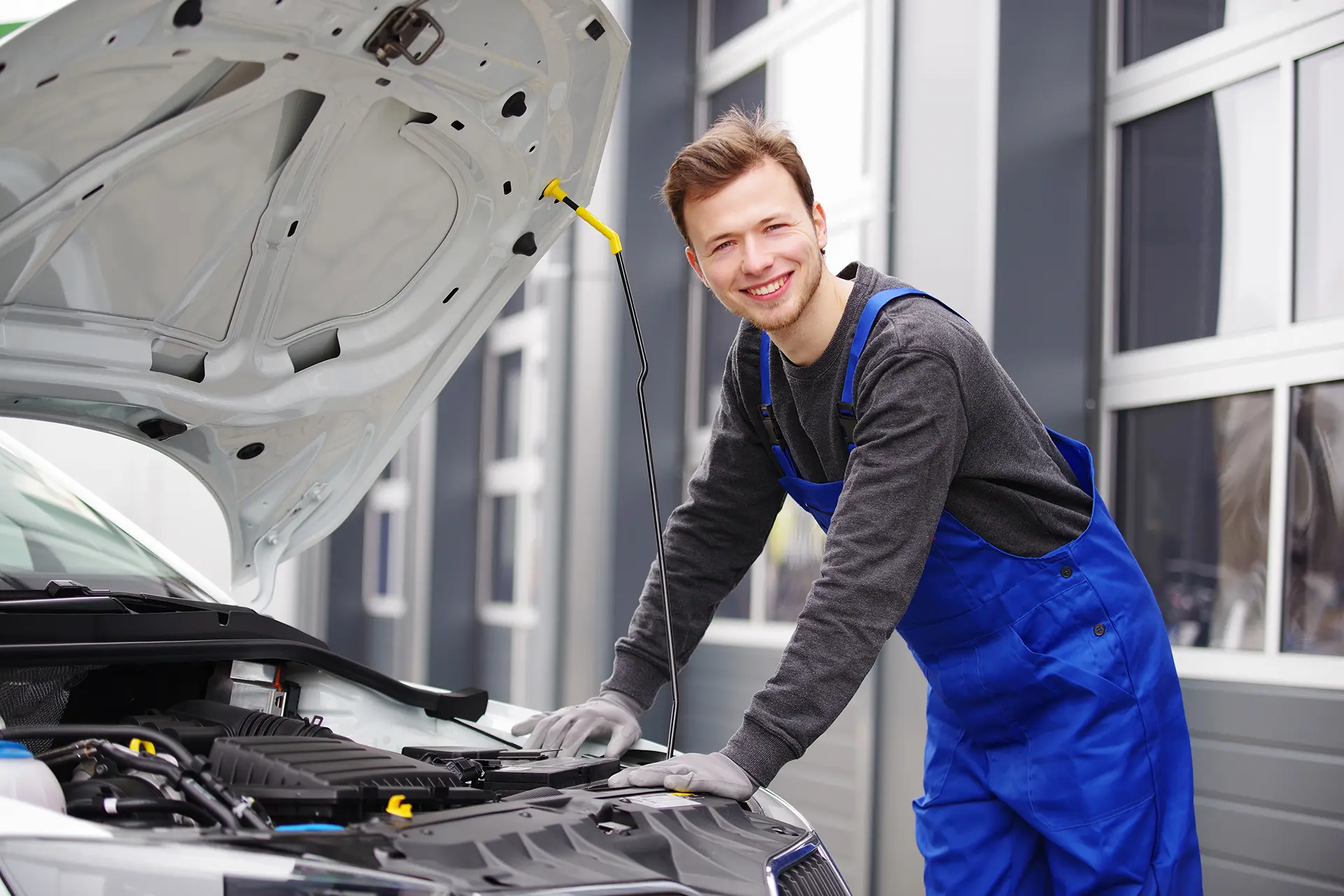 Automechaniker sympathisch lächelnd inspiziert einen Motor